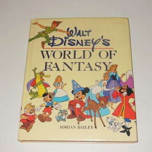 Peut inclure: Un livre jaune intitulé "Walt Disney's World of Fantasy" avec une illustration de divers personnages Disney, dont Mickey Mouse, Peter Pan et Cendrillon.