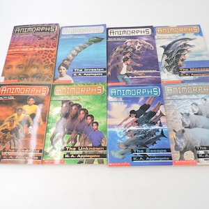 Puede incluir: Una colección de libros de Animorphs, con portadas vibrantes que ilustran varias criaturas y escenas. Los títulos incluyen "The Invasion", "The Encounter" y "The Warning". Los libros son de K.A. Applegate.
