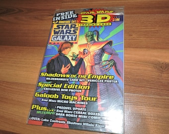 Może przedstawiać: Magazyn Star Wars Galaxy z kartą kolekcjonerską 3D. Okładka przedstawia Luke'a Skywalkera walczącego z czarnym charakterem. Magazyn zawiera treści o Shadows of the Empire, Galoob Toys i innych tematach Star Wars. Magazyn jest zapieczętowany w plastiku.