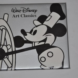 May include: A black and white illustration of Mickey Mouse as a sailor, holding a ship's wheel. The image is on a silver background with the text "Walt Disney Art Classics".