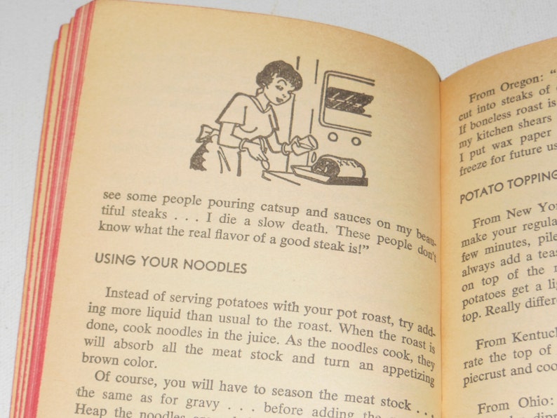 May include: A vintage cookbook with a red and white striped cover. The book features a black and white illustration of a woman pouring gravy over a roast. The text on the page reads "Using Your Noodles" and "Potato Topping".