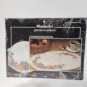 May include: A package of WonderArt quilted placemats with a floral design. The package includes 4 pre-finished quilted placemats.