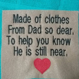 May include: A beige fabric square with black embroidered text that reads "Made of clothes From Dad so dear, To help you know He is still near." A red embroidered heart is below the text.