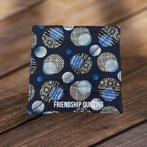 May include: A blue and white fabric square with a circle pattern and the text "FRIENDSHIP QUILTING".