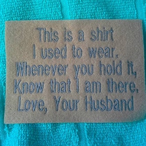 May include: A brown card with the text "This is a shirt I used to wear. Whenever you hold it, Know that I am there. Love, Your Husband" embroidered in gray thread.