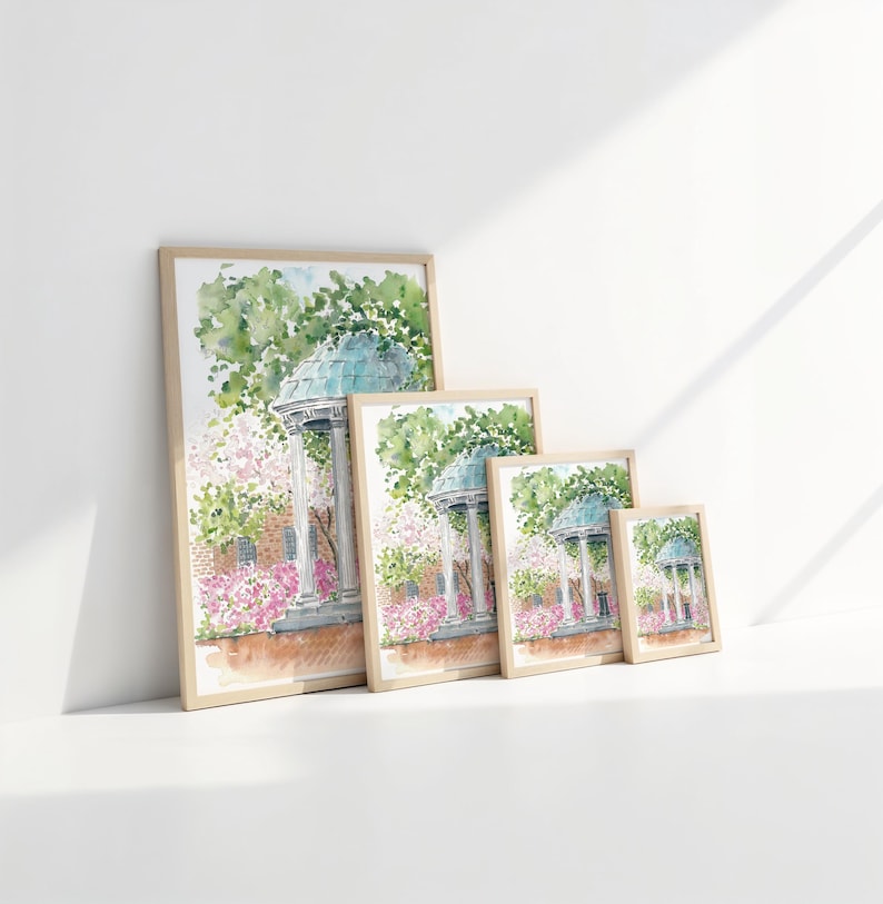 Puede incluir: Cuatro acuarelas enmarcadas de un cenador blanco con techo azul rodeado de flores rosas y &aacute;rboles verdes. Las pinturas son de diferentes tama&ntilde;os y est&aacute;n dispuestas en fila sobre una superficie blanca.