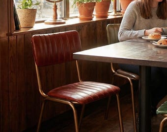 Moderne metalen eetkamerstoel uit het midden van de eeuw, met accent gestoffeerde leren stoel, restaurant- en hotelinterieur, industrieel primitief meubilair