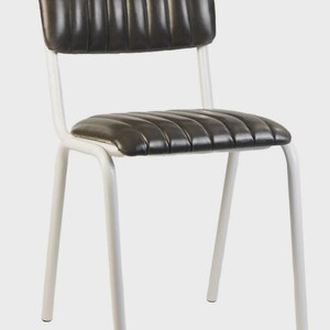 May include: A black and white chair with a padded seat and back. The seat and back are black with vertical stitching. The frame is white and made of metal. The chair has four legs.