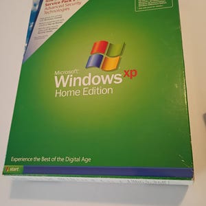 May include: A green Microsoft Windows XP Home Edition software box. The box features the Windows logo with red, blue, yellow, and green squares. Text on the box includes "Service Pack 2" and "Experience the Best of the Digital Age."