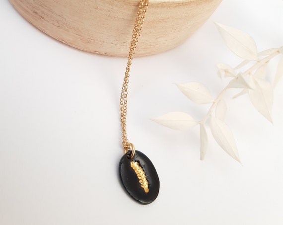 Short black gold necklace with handmade oval black porcelain pearl with gold leaf