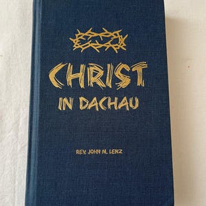 May include: A navy blue book titled "CHRIST IN DACHAU" with gold lettering and a gold crown of thorns illustration. The author's name, Rev. John M. Lenz, is printed at the bottom.