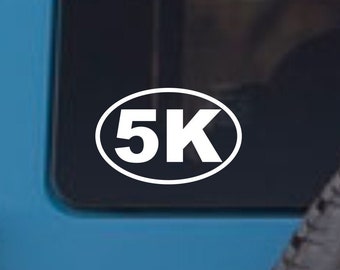 Könnte beinhalten: Weißer Vinyl-Aufkleber mit dem Text "5K" in einer weißen ovalen Form auf einem blauen Auto.