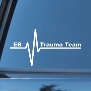 May include: White vinyl decal with a heartbeat graphic and the text "ER Trauma Team" on a blue car window.