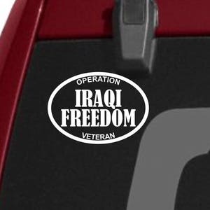 May include: A white vinyl sticker with the text "Operation Iraqi Freedom Veteran" in a circle on a red car.