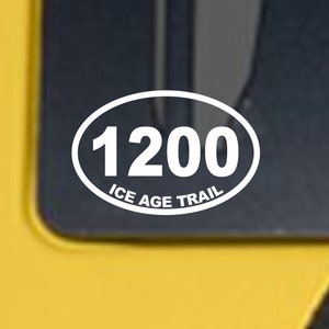 May include: White oval sticker with the text "1200 Ice Age Trail" on a yellow vehicle.
