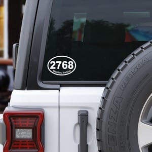 May include: White oval sticker with the number 2768 and the text " Manitou Incline" on a black car window.