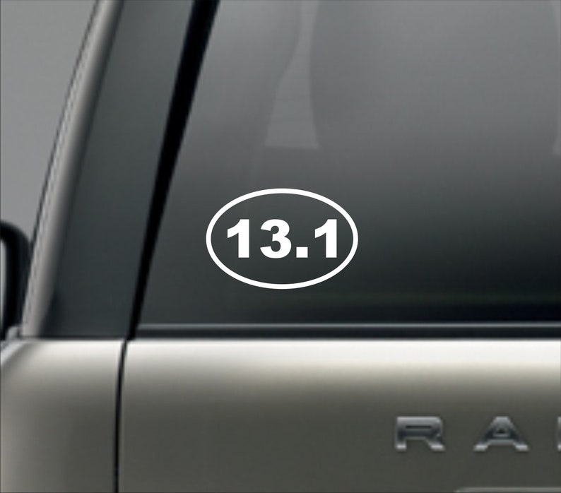 Puede incluir: Pegatina ovalada blanca con el n&uacute;mero 13.1 impreso en blanco en una ventana de coche negra.