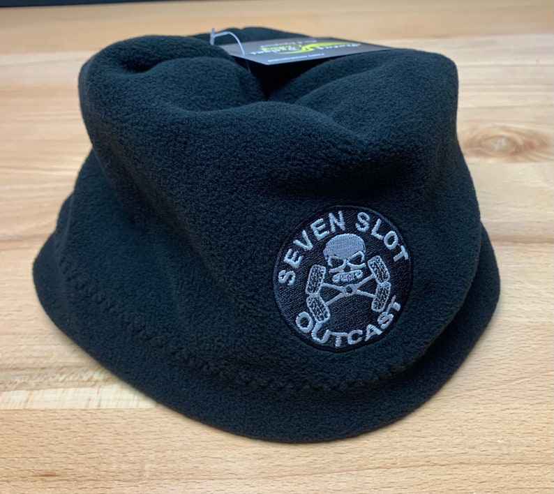 May include: Black fleece neck warmer with a gray embroidered logo that says "Seven Slot Outcast" and features a skull and crossbones.