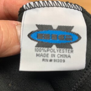 May include: A white tag with black text and a blue logo that says "BIG" in a circle. The tag says "100% Polyester Made in China RN # 91309".