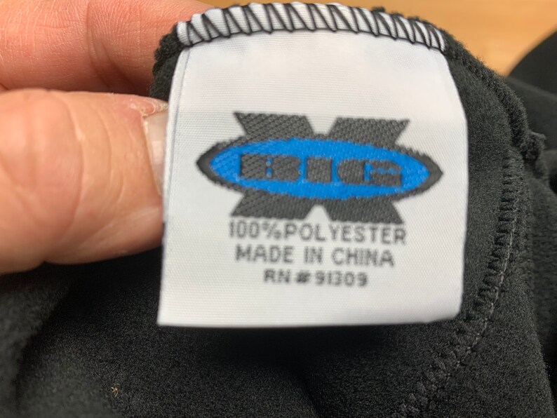 May include: A white tag with black text and a blue logo that says "BIG" in a circle. The tag says "100% Polyester Made in China RN # 91309".