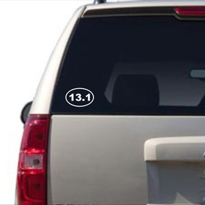 Puede incluir: Pegatina ovalada blanca con el texto "13.1" en un coche plateado.