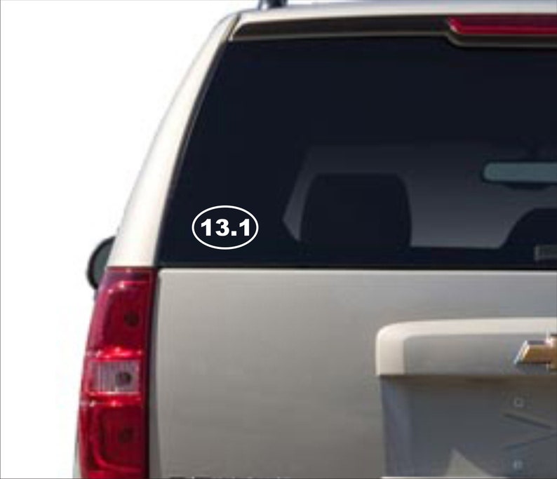 Puede incluir: Pegatina ovalada blanca con el texto "13.1" en un coche plateado.