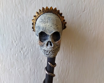 Koninginnenschedel met een slangenscepter, dit is een memento mori geïnspireerd kunstwerk, geheel met de hand gemaakt, een griezelige coole stick art pop om op te hangen.