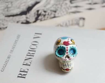 Teschio di Halloween scolpito a mano in paper clay dipinto con motivi floreali, ispirato al Messico e all'arte folk, miniatura cranio.