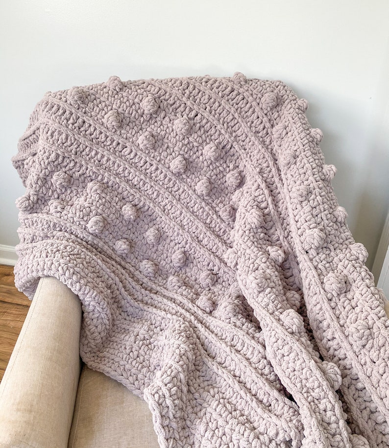 May include: A soft, plush, mauve-colored crochet throw blanket with a textured, bobble stitch pattern.