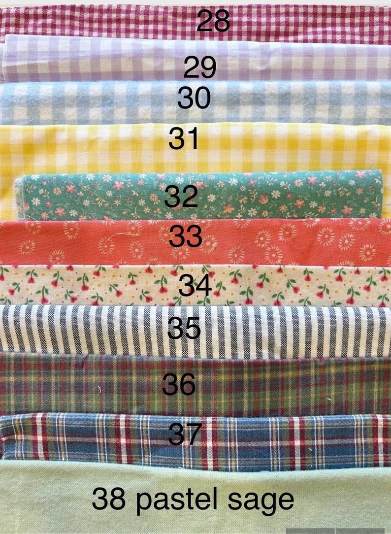 May include: A collection of eleven fabric swatches stacked vertically, labeled 28 through 38. Patterns include gingham in maroon, lavender, blue, and yellow, floral prints in green, coral, and white, black and white stripes, and various plaid designs.