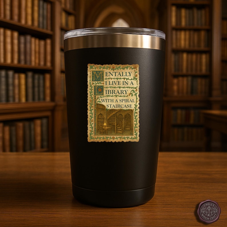 May include: Black insulated tumbler with a silver rim. The tumbler features a vintage-style sticker with the text "Mentally I live in a library with a spiral staircase." The sticker has a green and gold border and a drawing of a library.