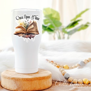May include: White tumbler with a sticker of an open book with the text "Once Upon A Time" and watercolor-style flowers and leaves.