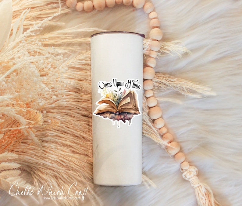 May include: White stainless steel tumbler with a vinyl decal of an open book with flowers and the text "Once Upon a Time".