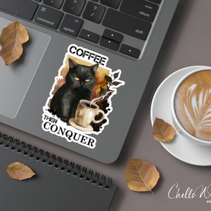May include: A black cat with green eyes sits with a steaming cup of coffee. The cat is surrounded by a watercolor background with fall leaves. The text "Coffee Then Conquer" is written below the cat.