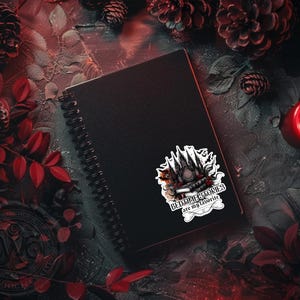 Puede incluir: Un cuaderno negro de espiral con una pegatina en la portada. La pegatina presenta una ilustraci&oacute;n en blanco y negro de un edificio g&oacute;tico con el texto "Bedtime Stories are my favorite".