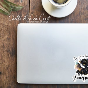 May include: A black and white sticker with a cartoon dragon and the text "I'm not a bookworm I'm a Book Dragon".