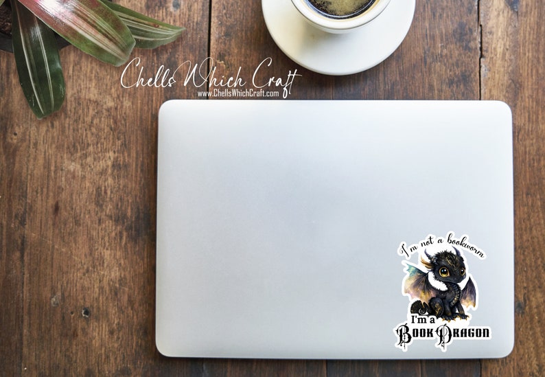 May include: A black and white sticker with a cartoon dragon and the text "I'm not a bookworm I'm a Book Dragon".