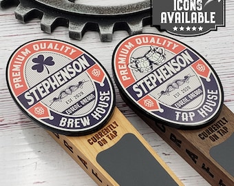 May include: Two wooden beer tap handles with custom labels. The labels are round and feature a blue, red, and white color scheme. The labels say "Premium Quality Stephenson Brew House" and "Premium Quality Stephenson Tap House".