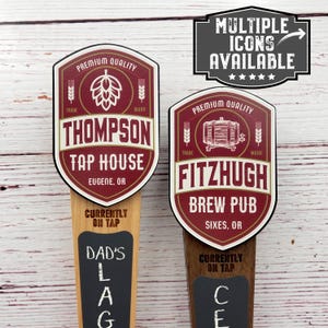 May include: Two wooden beer tap handles with chalkboard signs. The top of each handle features a red and white logo with the text "Thompson Tap House, Eugene, OR" and "Fitzhugh Brew Pub, Sixes, OR".