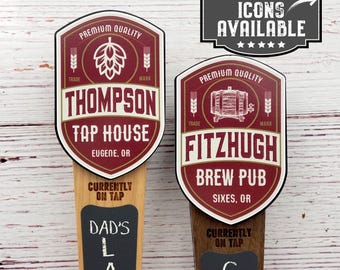 May include: Two wooden beer tap handles with chalkboard signs. The top of each handle features a red and white logo with the text "Thompson Tap House, Eugene, OR" and "Fitzhugh Brew Pub, Sixes, OR".