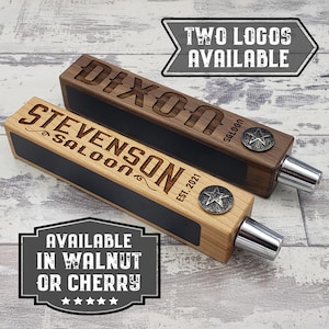 May include: Two wooden tap handles, one light and one dark, with engraved text and star-shaped accents. The light handle reads "STEVENSON SALOON EST. 2021". The dark handle reads "DIXON SALOON". The image also says "TWO LOGOS AVAILABLE" and "AVAILABLE IN WALNUT OR CHERRY".