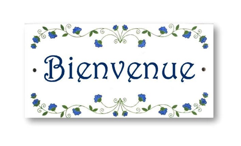 May include: White ceramic sign with blue floral border and the text "Bienvenue" in navy blue.