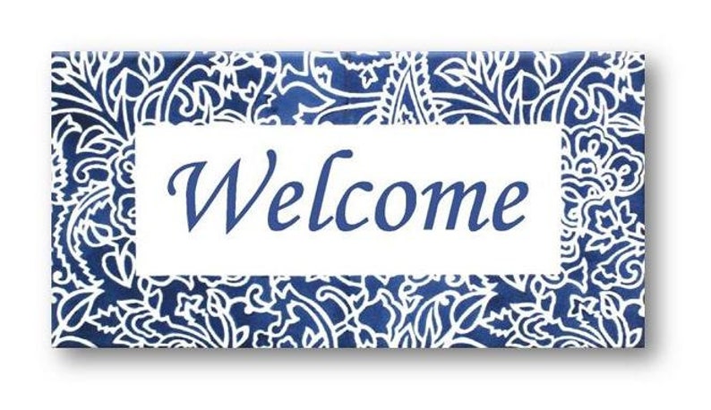 May include: A blue and white welcome sign with a paisley pattern. The sign says "Welcome" in a white font.