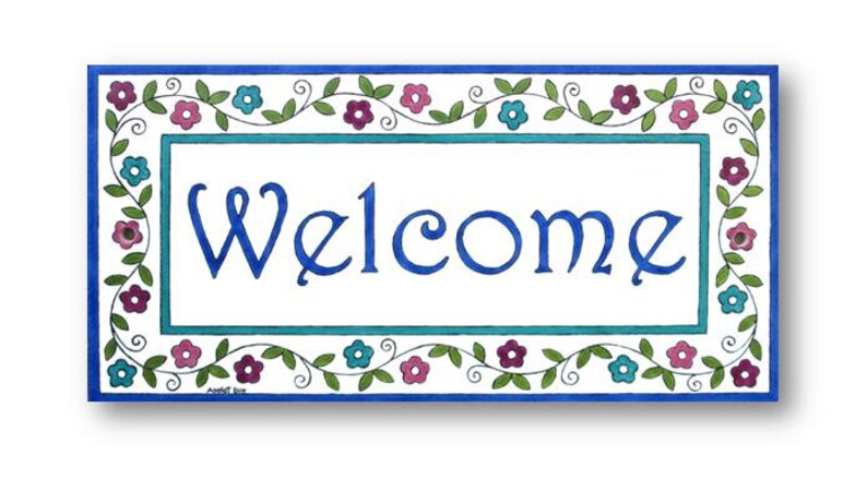 May include: A white welcome sign with a blue border and a blue floral design. The word "Welcome" is written in blue cursive lettering.