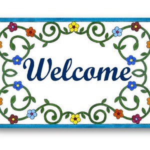 May include: A white ceramic welcome sign with a blue border and a green floral design. The word "Welcome" is written in blue cursive lettering.