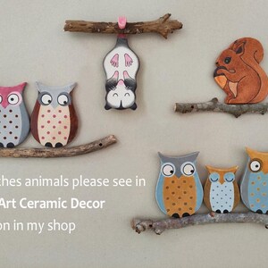 May include: Ceramic wall art featuring a variety of animals, including owls, a squirrel, and a sugar glider. The animals are painted in bright colors and are attached to wooden branches. The text "Branches animals please see in Wall Art Ceramic Decor section in my shop" is visible at the bottom of the image.