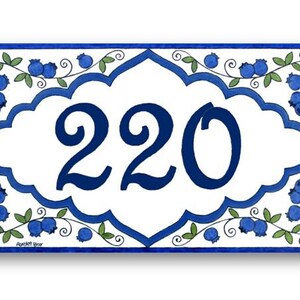 May include: A white ceramic house number sign with a blue border and blueberry design. The number 220 is displayed in a blue font.