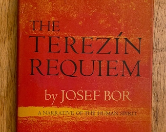 May include: A red book with the title "The Terezin Requiem" by Josef Bor. The subtitle is "A Narrative of the Human Spirit".