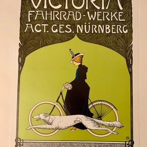 May include: A vintage poster advertising Victoria Fahrrad-Werke, a bicycle manufacturer in Nuremberg, Germany. The poster features a woman in a black dress and hat riding a bicycle with a white dog running alongside. The text "VICTORIA FAHRRAD-WERKE ACT. GES. N&Uuml;RNBERG" is displayed in a decorative font.