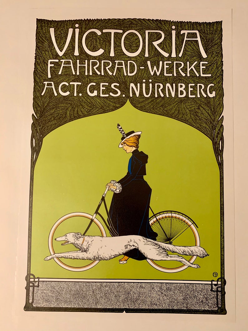 May include: A vintage poster advertising Victoria Fahrrad-Werke, a bicycle manufacturer in Nuremberg, Germany. The poster features a woman in a black dress and hat riding a bicycle with a white dog running alongside. The text "VICTORIA FAHRRAD-WERKE ACT. GES. N&Uuml;RNBERG" is displayed in a decorative font.